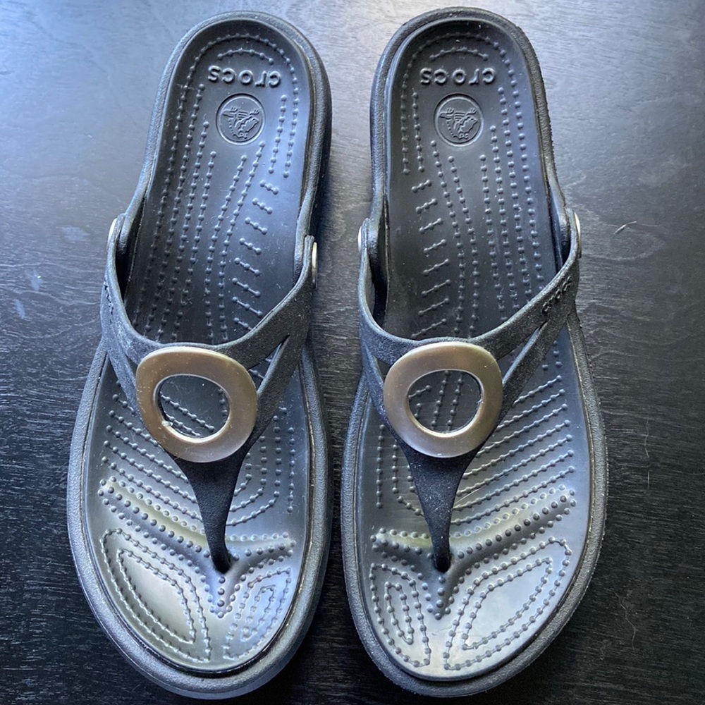 Crocs flip flops.  Black rubber with silver colored circle. Size 6. Barely worn.